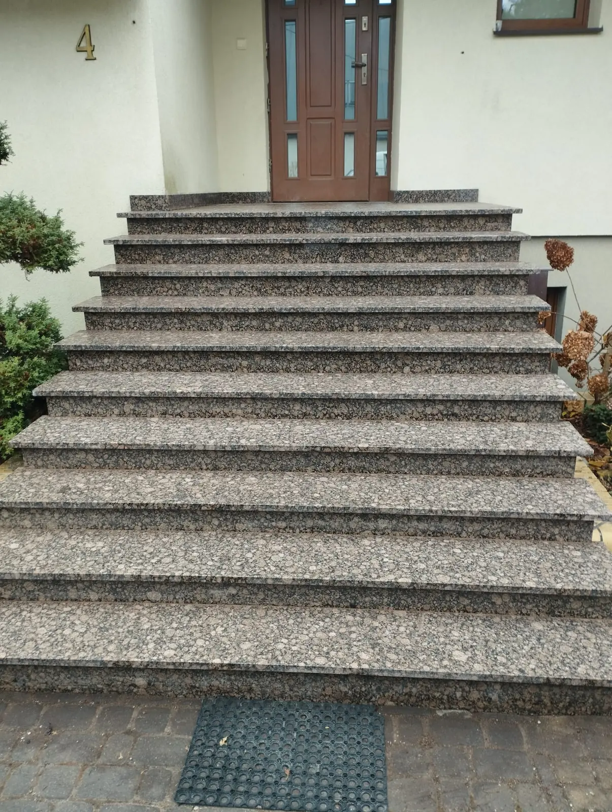 Szerokie schody wejściowe z granitu o naturalnym wyrazistym wzorze