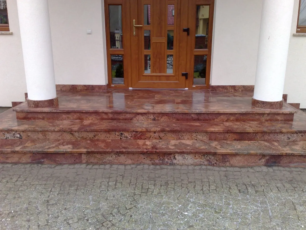 Schody i podest wejściowy z polerowanego kamienia w ciepłym odcieniu